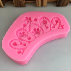 Pink silicone crown mold for DIY cake fondant and chocolate making on a grey surface
