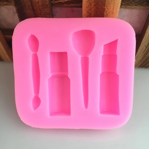 Pink silicone mold featuring lipstick and makeup brush shapes for DIY fondant and soap making