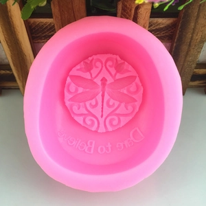 Pink silicone mold for lotus and dragonfly soap with Dare to Believe relief text