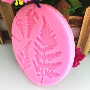 Pink silicone leaf mold for fondant cake decorating featuring intricate fern leaf textures