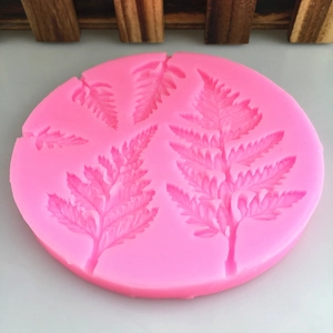 Pink round silicone leaf mold for fondant and resin featuring detailed fern leaf textures