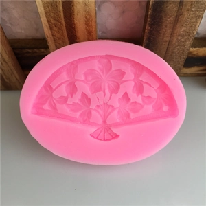 Pink silicone folding fan mold featuring intricate floral and leaf patterns for DIY baking