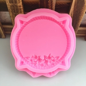 Detailed macro view of pink silicone mold featuring intricate rose relief and radial edges