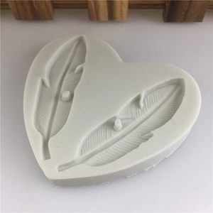 Heart shaped white silicone mold featuring dual feather patterns for DIY cake decorating