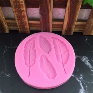 Moule en silicone rose avec quatre motifs de plumes pour gâteaux et bougies