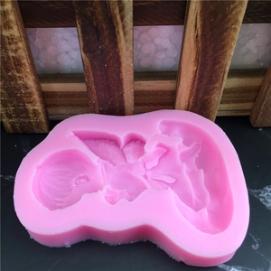 Pink silicone angel mold for fondant and chocolate decoration on black stone surface