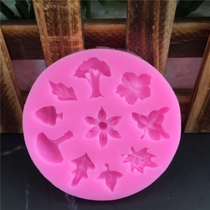 Pink silicone mold featuring nine distinct plant leaf and tree shapes for fondant and cake decor