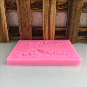 Pink silicone mold for cake borders with baroque scroll patterns and wings style