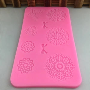 Pink silicone fondant mold featuring flowers, hearts, and bowknot shapes for cake decorating