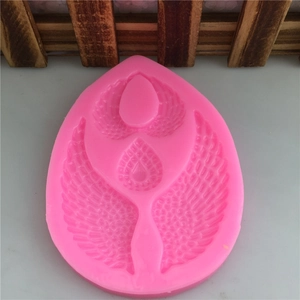 Detail of pink silicone mold featuring intricate angel wings and teardrop heart patterns