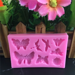 Pink silicone mold featuring butterfly and dragonfly shapes for fondant cake decorating