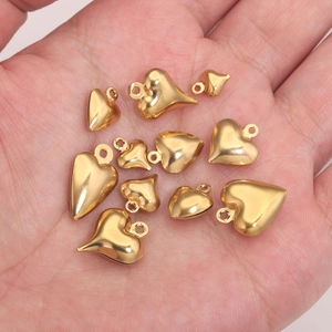 Gepolijste gouden holle hartbedeltjes in verschillende maten voor doe-het-zelf sieraden