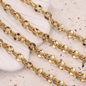 Macro shot of polished 7mm gold-plated stainless steel cable chain on a stone background