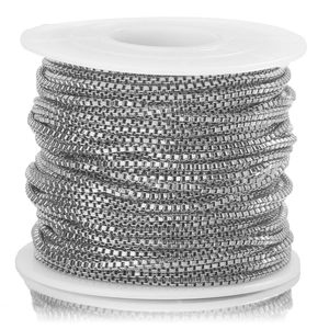 Macro shot of silver stainless steel box chain wound on a white plastic spool for DIY jewelry
