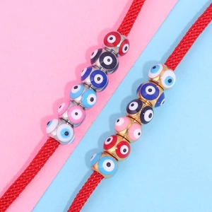 Colorful evil eye enamel cube beads on red braided cords with vibrant dual-tone background