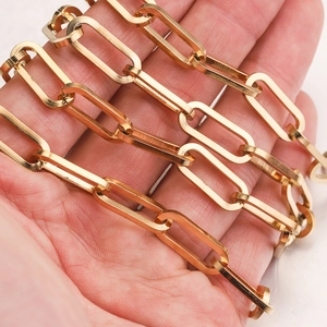Détail de la chaîne trombone en acier inoxydable doré 7mm présentée au creux de la main