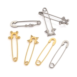 Detail van roestvrijstalen veiligheidsspeld broches in goud en zilver met kralen en studs