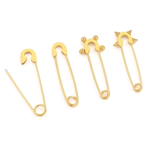 Detailweergave van vier minimalistische gouden veiligheidsspeld oorbellen en accessoires