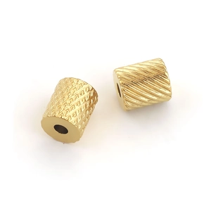 Macro view of textured stainless steel gold-plated cylinder beads for DIY jewelry making