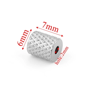 Detailed macro view of silver textured 7x6mm stainless steel tube bead with 2mm hole