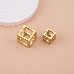 Macro-opname van twee gouden holle kubusbedels met een minimalistisch geometrisch ontwerp