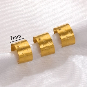 Détail de trois bagues d'oreille dorées en acier inoxydable de 7mm à motifs d'étoiles