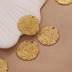 Goldene Herzanhänger aus Edelstahl mit Hammerschlag-Textur auf edlem Seidenhintergrund
