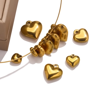 Macro shot of polished gold-plated heart pendants in various sizes on a white background