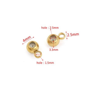 Vista macro di perle in acciaio inossidabile dorato per gioielli da 4 mm e 3,3 mm