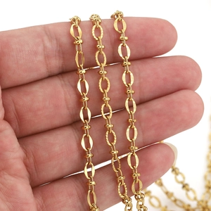 Gold plated stainless steel oval cuban link chain with textured surface held in hand