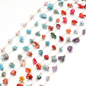 Detailed macro view of colorful irregular natural stone bead chain with gold spacer beads