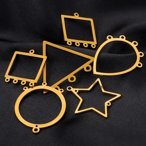 Détail macro de connecteurs de bijoux géométriques plaqués or sur satin noir élégant