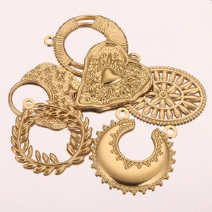 Détail macro des pendentifs vintage en acier inoxydable doré avec cœur et couronne