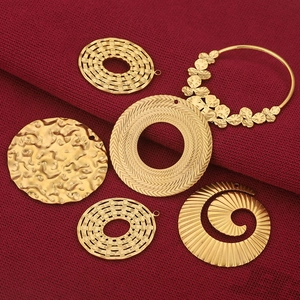 Lot de six pendentifs en acier inoxydable doré aux motifs floraux et géométriques