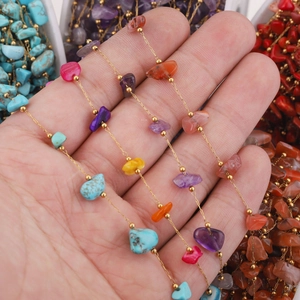 Hand holding a colorful natural stone stainless steel bead chain necklace or bracelet