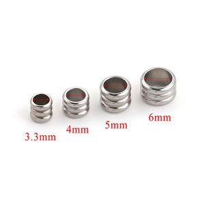 Detailed view of stainless steel spacer beads with grooved texture in four sizes