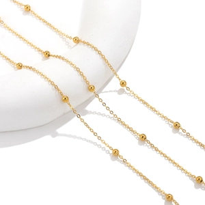 Polished gold stainless steel satellite bead chain necklace on geometric white display