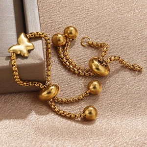 Adjustable gold butterfly charm bracelet with drawstring closure on silk background