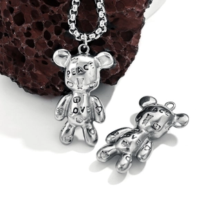 Vintage stainless steel bear necklace with Peace Love graffiti on dark volcanic rock