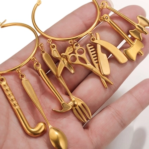 Gold stainless steel hoop earrings with hanging tools like scissors, combs, and spoons