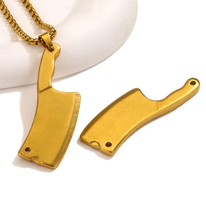 Macro shot of gold stainless steel kitchen knife pendants on a box chain necklace