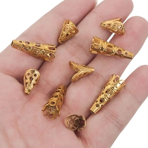 Eight gold filigree flower bead caps for DIY jewelry making displayed on a palm