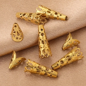 Golden stainless steel filigree cone end caps for DIY jewelry making on satin