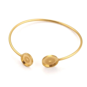 Detail van een gouden roestvrijstalen open armband met twee ronde bezel-zettingen voor DIY