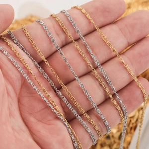 Macro detail of gold and silver twisted water ripple chains wrapped around a hand