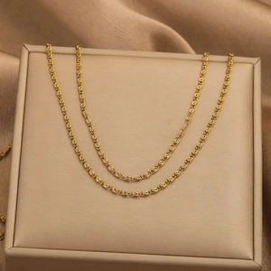 Elegant gold-tone stainless steel S-shaped spiral chain necklace displayed on silk fabric