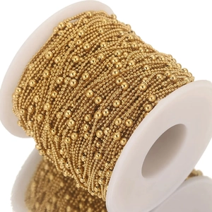 Golden stainless steel bead chain on a white spool for DIY jewelry making and necklace crafting