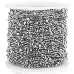 Macro shot of silver stainless steel beaded ball chain wound on white plastic reel spool