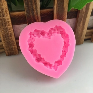 Pink heart-shaped silicone mold featuring intricate rose flower textures for DIY baking