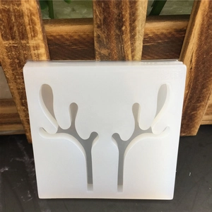 Close-up of a square white silicone mold with a detailed antler cutout for DIY crafts